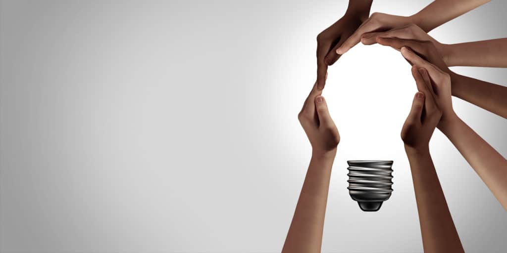 hands coming together to form the shape of a lightbulb